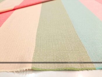 Pasztell csíkos dekorvászon tavasz színekkel hajtott, látszik a szél